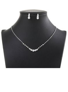 a necklace and earring set on a mannequin neckline with white beads