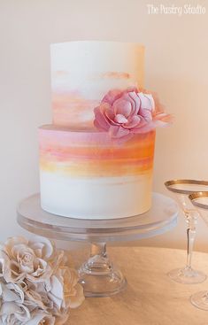 a white and pink cake sitting on top of a table