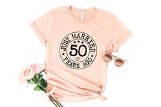 50th Wedding Anniversary Shirts, Parents Tshirt, 50th Wedding tshirt, 50th Anniversary Married Tshirt, 50 Years Custom Shirt, Gift for her -----PRODUCT----- → All our simple color ones like White and Black are 100% Cotton. → All our Heather Colors are cotton/polyester blend and they are super comfy soft! → Short Sleeve Crew-Neck Unisex T-Shirt → Soft and High-Quality Fabric → Sown Jersey → Pre-shrunk → Taped shoulder-to-shoulder → Tear away label → Side Seamed → Retail fit -----How To Order----- 1-) Please, check and review all photos 2-) Choose your t-shirt size and color *Different styles of shirts may have different shades of same color choice due to different manufacturer brands. *For this reason, we recommend you to match shirts from the same styles if you want precisely matching colo Crew Neck T-shirt For Anniversary In Summer, Summer Anniversary Crew Neck T-shirt, Summer Crew Neck T-shirt For Anniversary, Anniversary Letter Print T-shirt For Summer, Summer Anniversary T-shirt With Letter Print, Wedding Anniversary Shirts, Wedding Tshirt, Anniversary Shirts, Wedding Tshirts