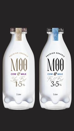 two bottles of moo cow milk on a black background