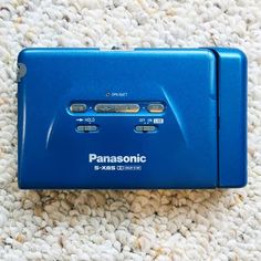 a blue electronic device sitting on top of a carpet