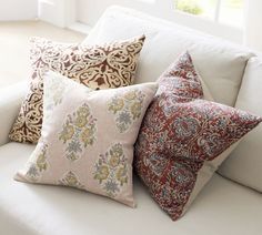 four decorative pillows on a white couch