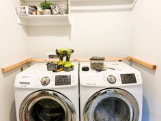 a washer and dryer in a small room with shelves above the washers