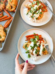 two plates with chicken, carrots and rice on them next to a baking pan