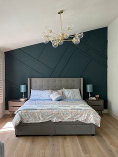 a bedroom with a bed, nightstands and a chandelier hanging from the ceiling