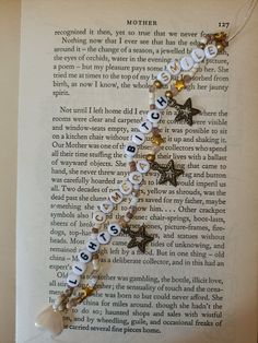 a book page with a star charm on it and the words mother written in small letters