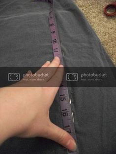 someone is measuring the length of their pants