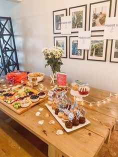 a wooden table topped with lots of desserts and pastries on top of it