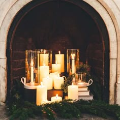 candles are lit in front of a fireplace