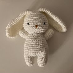 a crocheted white stuffed animal sitting on top of a table