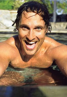 a man is smiling while swimming in the pool