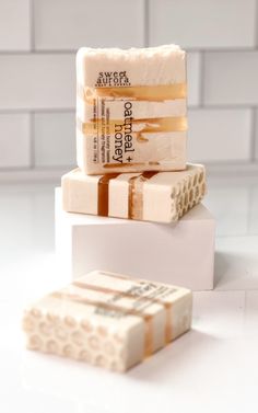 three soap bars stacked on top of each other in front of a white tiled wall