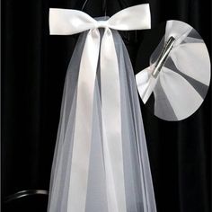 a chair with a white bow tied to it's back, and a piece of ribbon on top