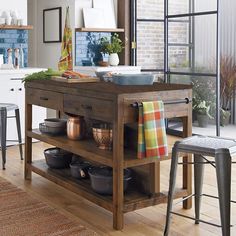 a kitchen island with pots and pans on it in the middle of a room