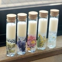 four glass bottles filled with different types of flowers