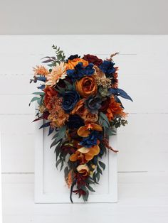 an orange and blue bouquet hanging on the side of a white door