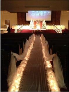 the aisle is covered with white fabric and lights for a wedding ceremony at st mary's church