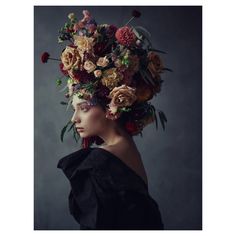 a woman with flowers on her head wearing a black dress and large flowered hat