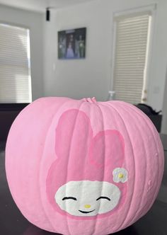 a pink pumpkin with a face painted on it