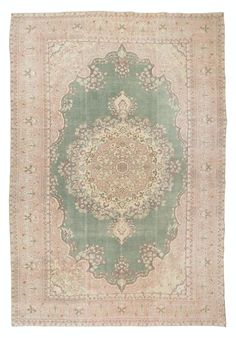 an antique rug with green and pink colors