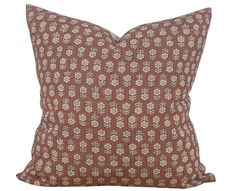 a brown and white pillow with leaves on it