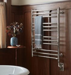 a towel rack in the corner of a bathroom next to a bathtub and window