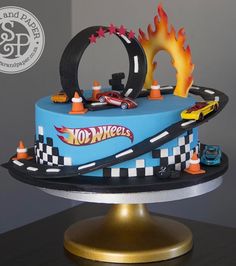 a blue cake with cars and flames on it