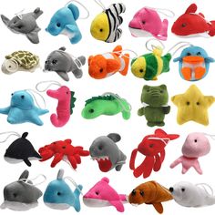 a bunch of stuffed animals that are in the shape of fish and dolphin heads on a white background