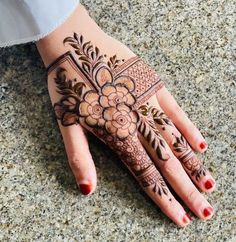 a woman's hand with henna tattoos on it