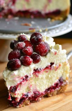 a piece of cheesecake with cranberries and whipped cream