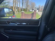 the interior of a car with a view of a driveway in the back ground and trees