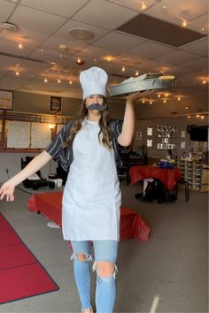 a woman in an apron and chef's hat holding a tray