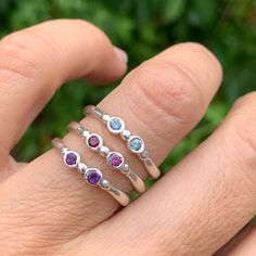 Wear them on their own or stacked all the way up your finger, our gemstone stacking bands in reclaimed sterling silver are the perfect addition to your daily jewels, a perfect gift for a loved one or yourself. Available in Ruby, Rhodolite Garnet, London Blue Topaz, Peridot, Amethyst, Blue Zircon, Spessartite Garnet, and Moonstone and mixed (pick your own stones) Each Stone measures approx 2.5mm. These beautiful pieces are handmade to order in Emily's Hudson Valley studio. Please allow 14-21 busi Everyday Stackable Jewelry With Round Stone, Sterling Silver Birthstone Ring For Everyday, Everyday Sterling Silver Birthstone Ring With Gemstone, Silver Stackable Gemstones As A Gift, Fine Jewelry Stackable Gemstones As Gifts, Silver Stackable Gemstones For Gift, Fine Jewelry Stackable Gemstones For Gift, Adjustable Stackable Rings In Bezel Setting - Fine Jewelry, Everyday Stackable Rings