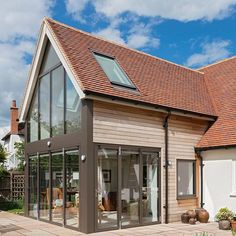 a house that has a lot of windows on the roof and some plants in front of it