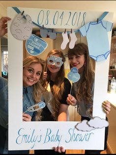 three girls holding up a baby shower sign