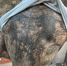 the back of a man with tattoos on his body