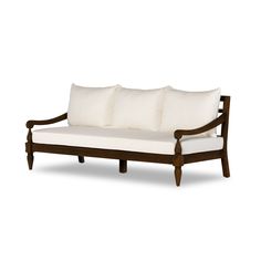 a wooden couch with three pillows on it's back and two white cushions on top