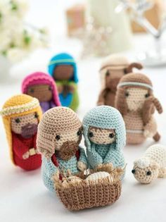 small crocheted nativity figurines are displayed on a table