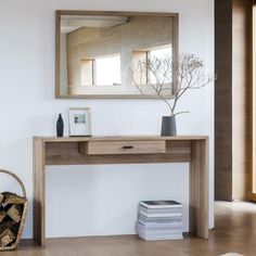 a wooden table with a mirror above it and a basket on the floor next to it