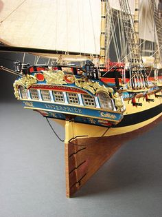 a model ship with many sails is on display