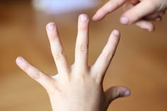 two hands reaching up towards each other to touch something on the table with their fingers