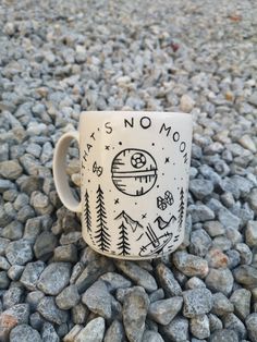 a white coffee cup sitting on top of a pile of rocks