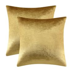 two gold velvet pillows sitting on top of each other