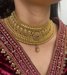 Exquisite Antique Gold Plated Choker Set featuring intricate designs and vibrant ruby stones. Complete with matching jhumkis and tika, this South Indian bridal jewelry set is perfect for weddings or special occasions. Elevate your traditional look with this timeless Indian wedding jewelry. Earrings are Approximately 1.6 Inches Long and one inch wide  A Earring Weight is 0.56 oz  raditional skills from our rich heritage. The manual nature of these crafts means that irregularities or variations may inherent in the handcrafting process. Long Gold Necklace Indian, Jewelry Indian Wedding, South Indian Bridal Jewellery, Indian Bridal Jewelry Sets, Gold Jewelry Simple Necklace, Antique Bridal Jewelry, South Indian Jewelry, Indian Bridal Wear, Indian Jewelry Sets