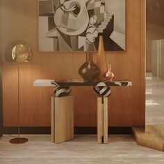 two vases sitting on top of a wooden table in front of a large painting