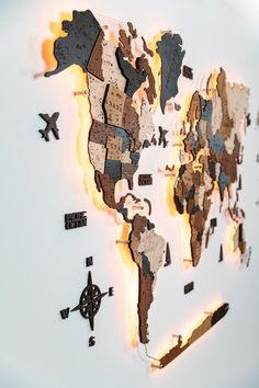 the world map is made up of different types of pieces of wood and has lights on each side