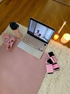 a laptop computer sitting on top of a pink mat