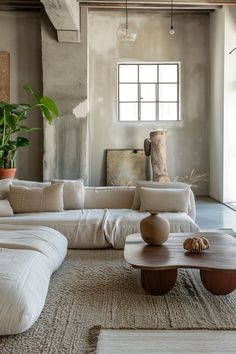 a living room filled with lots of furniture and plants on top of the couches