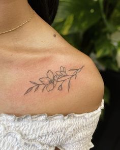 a woman with a flower tattoo on her shoulder