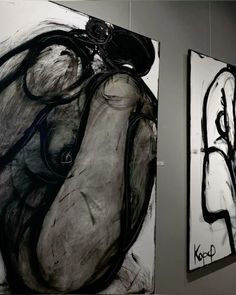 two black and white paintings hanging on the wall